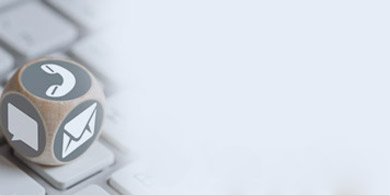 Kontakt-Symbole auf Holzwuerfel auf Tastatur